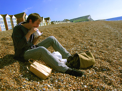 Joe eating a pasty on the beach at Seaford