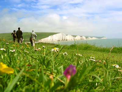 Walkers on path at Cliff Bottom, near Cuckmere Haven. Seven Sisters in the background.