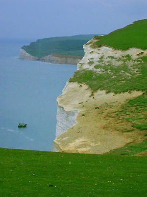 White cliffs, Seven Sisters, coast path, chalk, green, grass, lush, sea, fishing boat, Cuckmere Haven, East Sussex, England, Britain, UK, May 2007